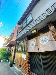 un edificio con una recinzione con due cartelli di guesthouse中道 ad Osaka