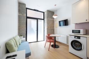 sala de estar con lavadora y mesa en Oriente Suites, en Madrid