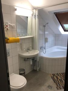 a bathroom with a toilet and a sink and a tub at Svájci Lak Panzió in Nyíregyháza
