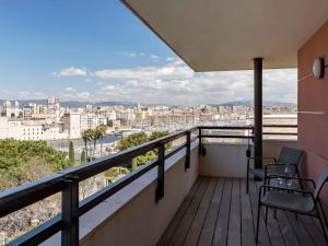 a balcony with two chairs and a view of a city at New Hotel of Marseille - Vieux Port in Marseille