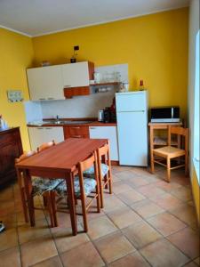 a kitchen with a table and a white refrigerator at Cascina Cantaret Agriturismo in San Marzano Oliveto