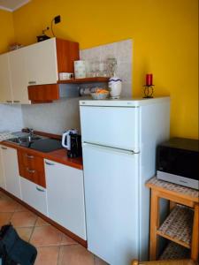 a kitchen with a white refrigerator and a microwave at Cascina Cantaret Agriturismo in San Marzano Oliveto +14 photos