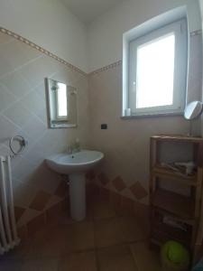 a bathroom with a white sink and a window at Cascina Cantaret Agriturismo in Agliano Terme
