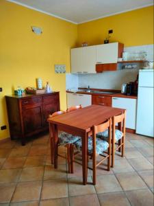 a kitchen with a wooden table and a refrigerator at Cascina Cantaret Agriturismo in Agliano Terme