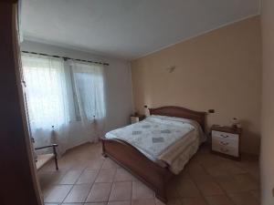 a bedroom with a bed and a tiled floor at Cascina Cantaret Agriturismo in Agliano Terme