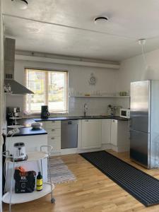 a kitchen with white cabinets and a stainless steel refrigerator at Blankaholm 1 nära marinan in Blankaholm