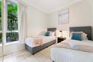 a bedroom with two beds and a window at Iconic Chevron Renaissance Private Apartments in Gold Coast +31 photos