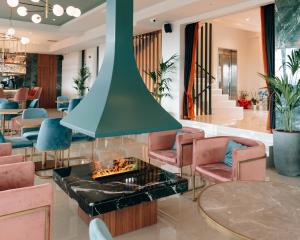 hol z kominkiem, krzesłami i stołami w obiekcie AKROTHEA suites & lounge w mieście Tripolis