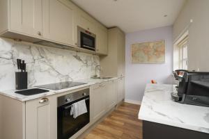 a kitchen with white marble counter tops and a sink at Central but quiet in Oxford