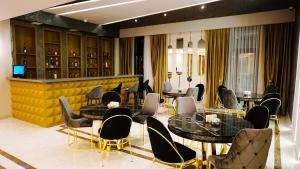 ein Restaurant mit Tischen und Stühlen und einer gelben Wand in der Unterkunft Sun City Hotel & Spa Naftalan in Naftalan