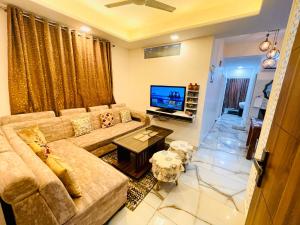a living room with a couch and a television at 3BHK Airport Vista Apartment - Entire Apartment in Jaipur
