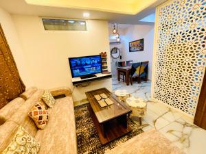 3BHK Airport Vista Apartment - Entire Apartment في جايبور: غرفة معيشة مع أريكة وتلفزيون