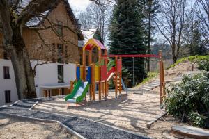 un parque infantil en un patio junto a una casa en Green Park Resort D26- z dostępem do basenu, sauny, jacuzzi, siłowni, en Szklarska Poręba