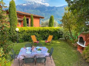 韦尔卡纳Giardino di Maria - Tulipano Panoramawohnung (OG)的房子院子里的一张桌子和几把椅子