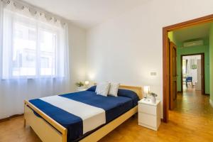 トルトレート・リドにあるAppartamento La Pinetina Trilo - MyHo Casaのベッドルーム(青と白のベッド1台、窓付)