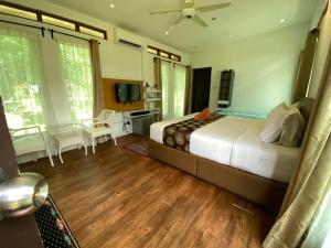 a bedroom with a large bed and a television at Sailor's Rest in Kampung Janda Baik