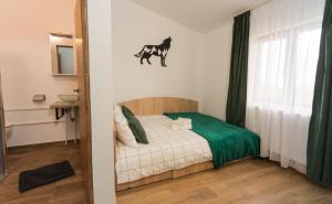 a bedroom with a bed with a horse on the wall at Vila Haiduk in Runcu