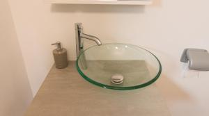 a glass sink in a bathroom with a faucet at Vila Haiduk in Runcu +44 photos