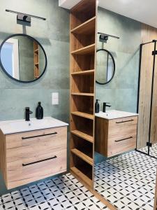 a bathroom with two sinks and a mirror at Zakątek Solny in Bochnia