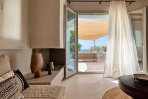 a living room with a door leading to a patio at Beachfront 3BR Villa Iremia in Naxos in Naxos Chora