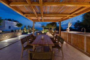 an outdoor patio with a wooden table and chairs and a sink at Beachfront 3BR Villa Iremia in Naxos in Naxos Chora