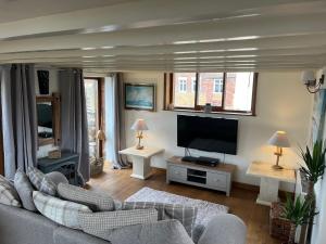 een woonkamer met een bank en een flatscreen-tv bij The Boathouse in Whitby