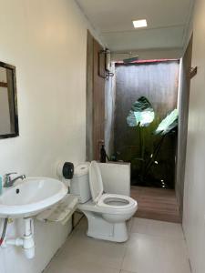 a bathroom with a white toilet and a sink at Sailor's Rest in Kampung Janda Baik
