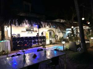 a table with blue lights on it at night at Bedrock Boutique Hostel in Baga