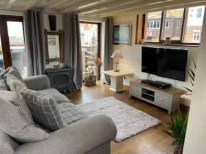 sala de estar con sofá y TV de pantalla plana en The Boathouse, en Whitby