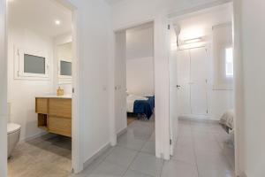 a white bathroom with a sink and a toilet at LA GOLA APARTMENT, First-line Beachfront, Newly Refurbished in Port de Pollensa +23 photos