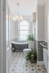 a bathroom with a tub and a toilet and a sink at The Surveyors House Devon, Luxury Victorian Villa in Torbay in Kingskerswell