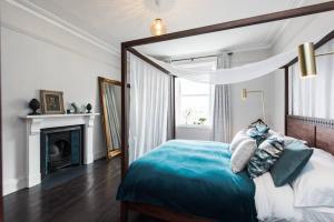 um quarto com uma cama com almofadas azuis e brancas em The Surveyors House Devon, Luxury Victorian Villa in Torbay em Kingskerswell