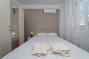 a bedroom with a white bed with towels on it at Danai Maisonettes Ofriniou in Ofrínion