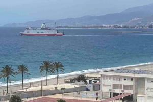 ein großes Boot im Wasser in der Nähe eines Strandes in der Unterkunft Torrenueva con vistas al mar in Torrenueva