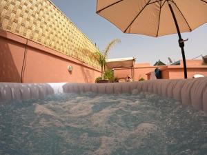 an umbrella sitting next to a swimming pool at Riad Le Marocain in Marrakech