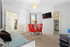 a living room with a table and red chairs at Maidstone Best 1 Bed City Centre Flat - Fast Wi-Fi in Maidstone