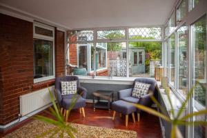 a screened in porch with two chairs and a table at Entire Family Home By The Sea in Scarborough