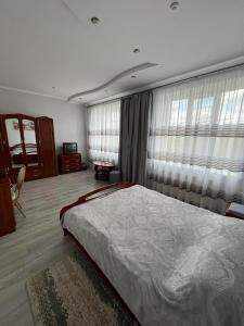 sypialnia z dużym łóżkiem i zasłonami w obiekcie Оазис w mieście Zalishchyky
