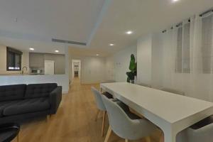 uma sala de estar com uma grande mesa branca e cadeiras em Luxury apartment in sevilla center em Sevilha