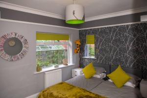 a bedroom with a bed and a mirror and yellow pillows at Entire Family Home By The Sea in Scarborough