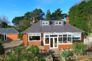 a red brick house with white windows at Entire Family Home By The Sea in Scarborough