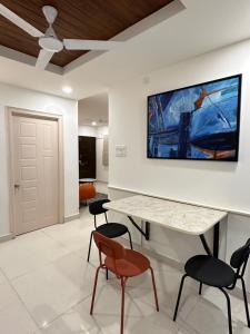 a living room with a table and chairs and a tv on the wall at Autumn suites in Hyderabad