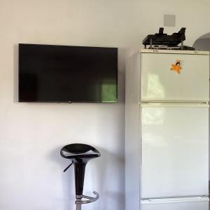 un tabouret noir posé sous un téléviseur à écran plat sur un mur dans l'établissement Casa Zorro, à Calp