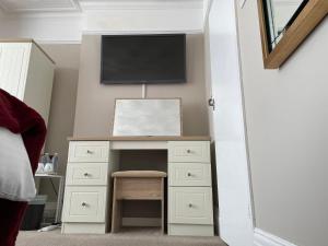 a bedroom with a desk with a tv on the wall at The Sandrock in Clacton-on-Sea
