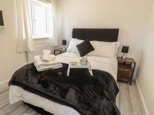 ein Schlafzimmer mit einem großen Bett mit einem Tisch darauf in der Unterkunft Old Colliery Cottage in Shilbottle