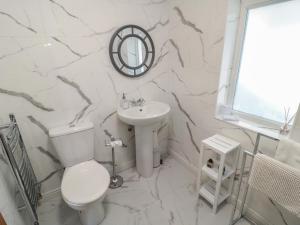 ein weißes Badezimmer mit Toilette und Waschbecken in der Unterkunft Old Colliery Cottage in Shilbottle + 11 Fotos