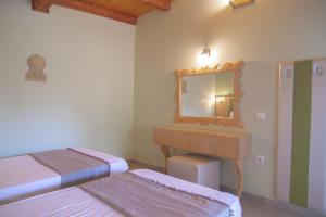 a room with two beds and a mirror and a sink at Villa Theodora View Apartments Erato in Agios Georgios Pagon