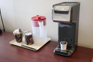 a coffeemaker and a coffee maker with cups on a table at Destination Family Hotel in Whitehorse +27 photos