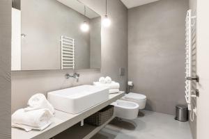 W łazience znajduje się umywalka, toaleta i lustro. w obiekcie Collection Moscova Suites - Top Collection w Mediolanie