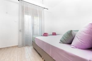 a bed with pink and green pillows in a room at Villa Alex Holiday Home in Kriopigi